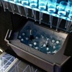 Built-in ice bar inside a black 20 seat party limo in Sydney, stocked with chilled drinks on ice and a rack of champagne flutes above the LED floor