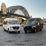 White and black 20 seat Mercedes Sprinter party limos parked in front of the Sydney Harbour Bridge