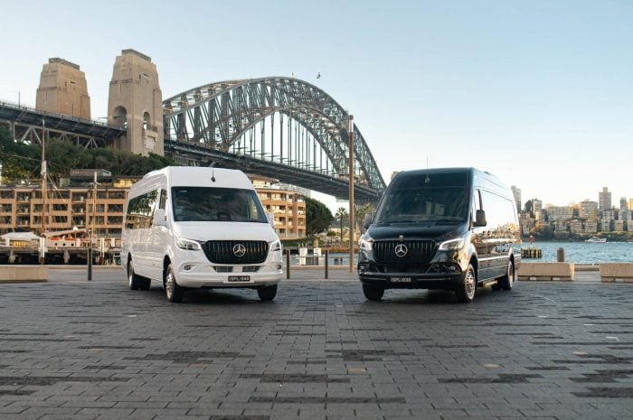 White and black 20 seat Mercedes Sprinter party limos parked in front of the Sydney Harbour Bridge at Circular Quay