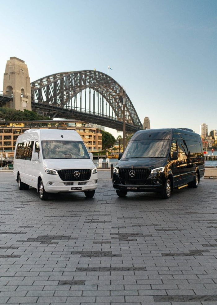 White and black 20 seat Mercedes Sprinter party limos parked in front of the Sydney Harbour Bridge
